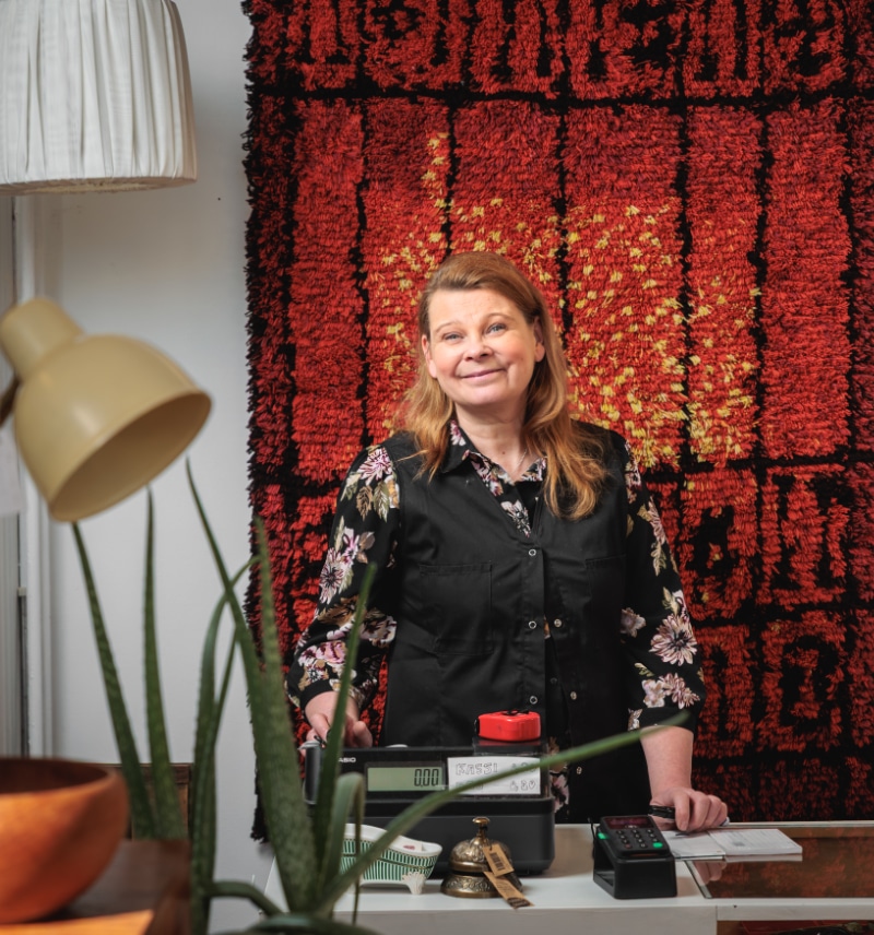 Vintagekauppa Millin yrittaja Jaana seisomassa tiskin takana myymalassa.