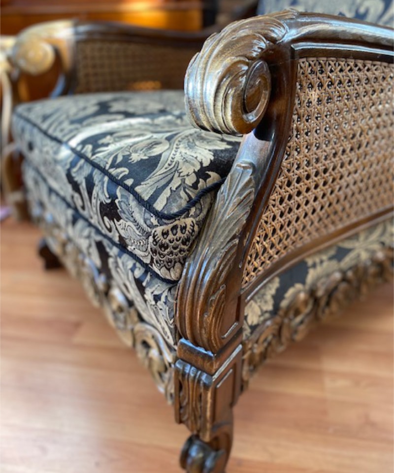 Koristeellisella kankaalla verhoiltu vanha nojatuoli.