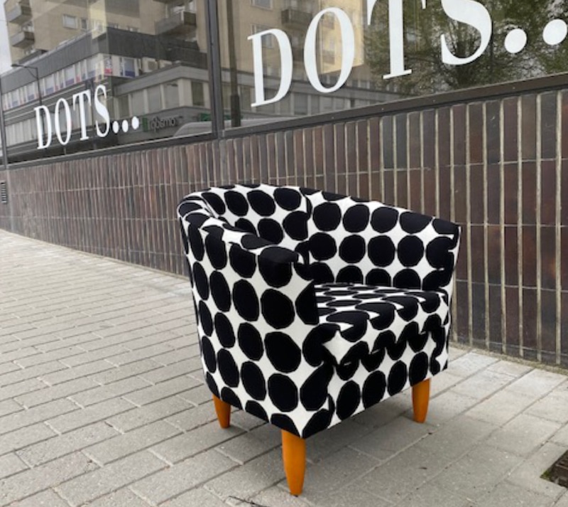 Vanha nojatuoli verhoiltu modernilla mustavalkoisella pallokankaalla.